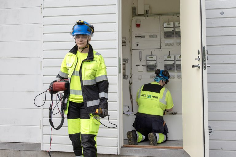 UVR:n työntekijät asentamassa ja huoltamassa sähköverkkoa taloyhtiön sähkönjakeluhuoneessa.