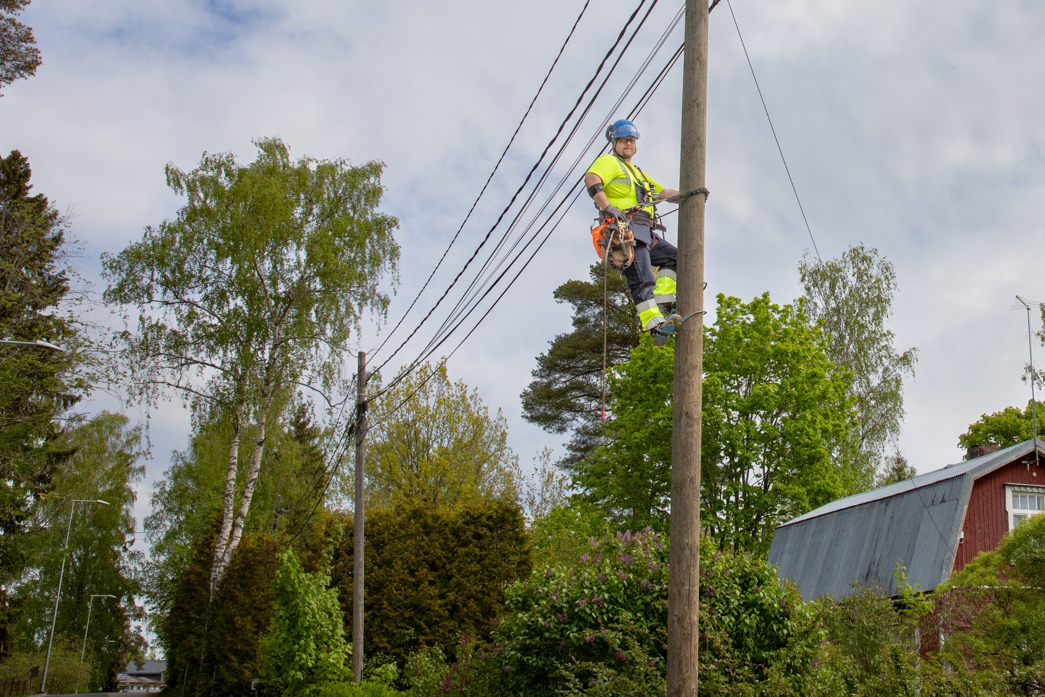 UVR:n asentaja kiipeää ylös sähkötolppaan.