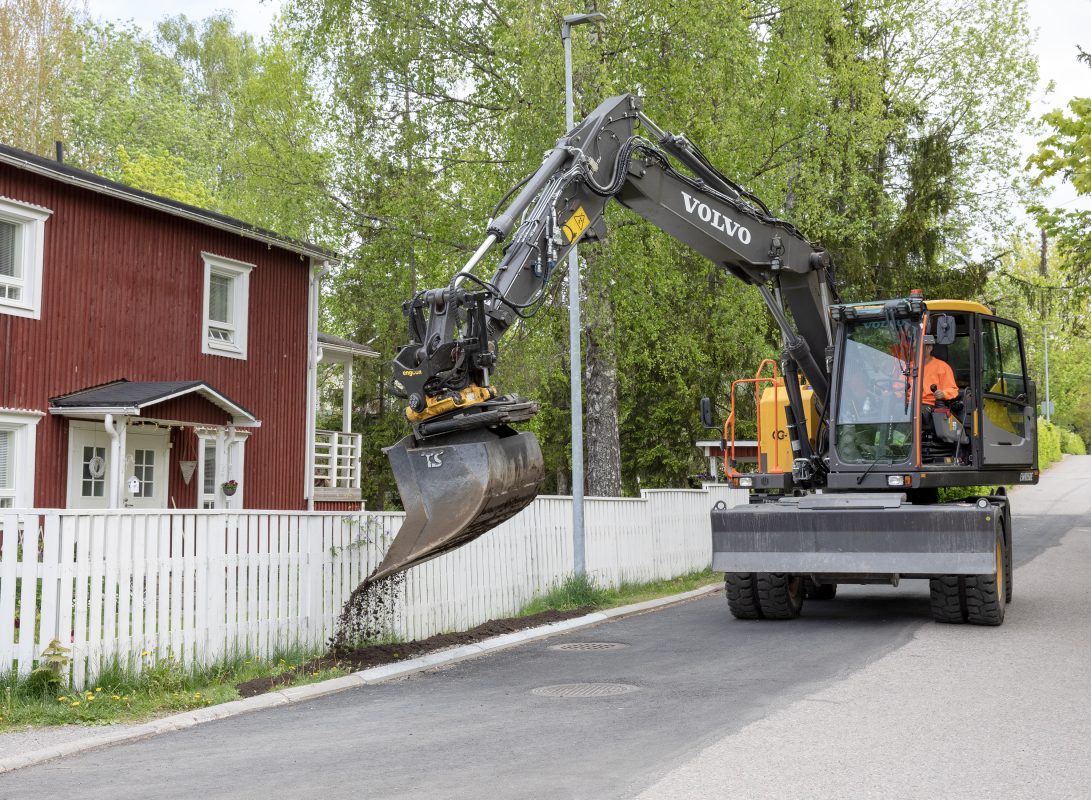 Kaivinkone tasoittaa maata asuinalueella
