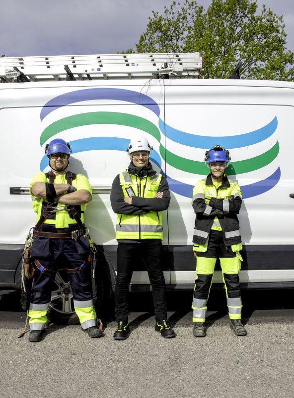 UVR:n kolme ammattihenkilöä seisovat vierekkäin työvaatteissa ja taustalla näkyy UVR:n pakettiauto UVR:n logolla.