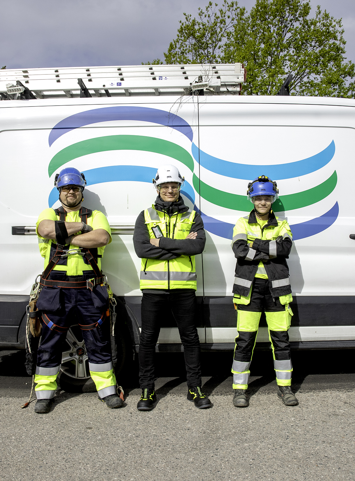 UVR:n kolme ammattihenkilöä seisovat vierekkäin työvaatteissa ja taustalla näkyy UVR:n pakettiauto UVR:n logolla.