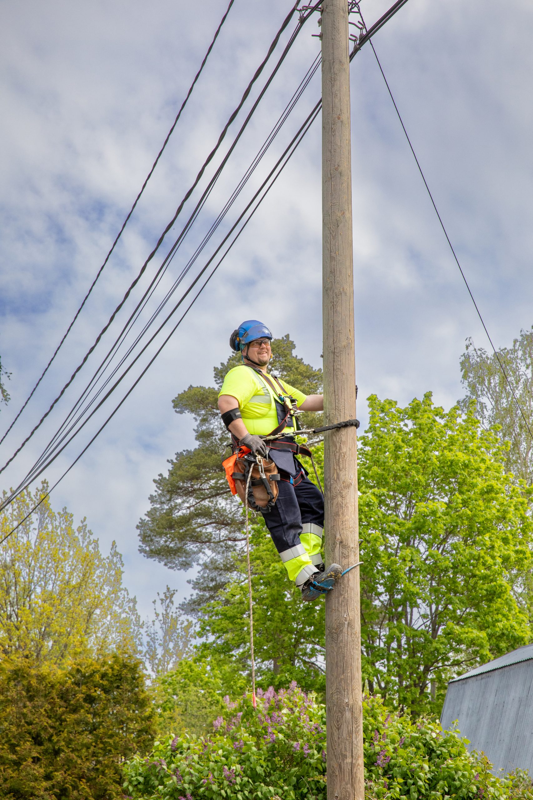 Referenssisivun taustakuvana yleiskuva sähkötolppaan kiipeävästä UVR:n työntekijästä