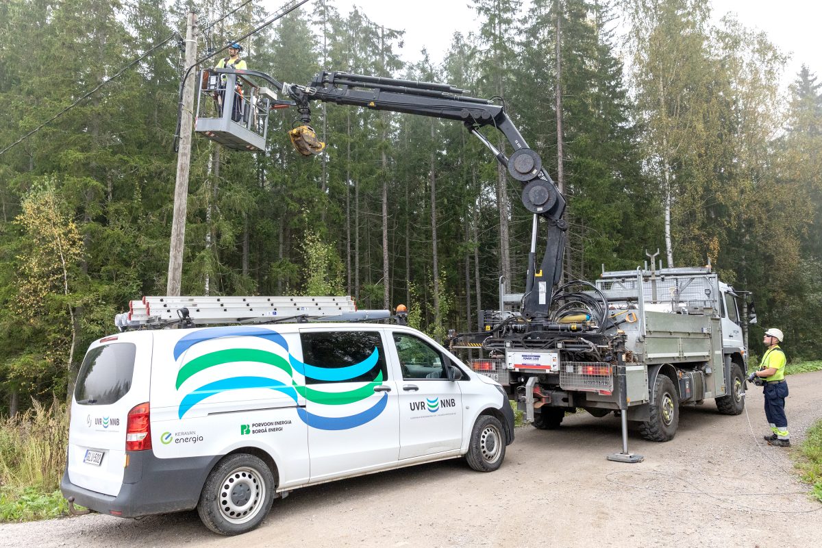 UVR:n kuorma-auto, jossa henkilönostin ja huoltoauto. UVR:n työntekijä käyttämässä nostinta, toinen asentaja henkilönostimessa.