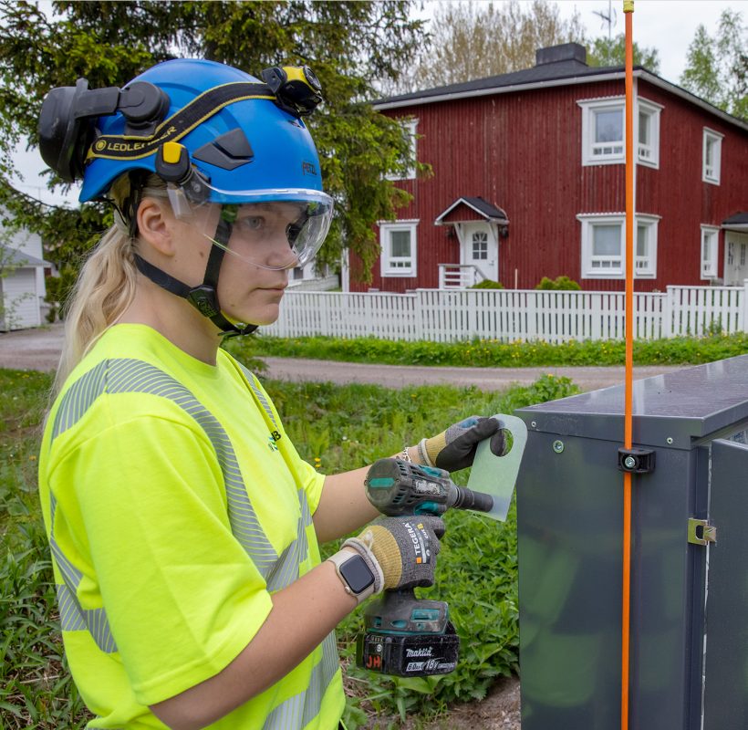 UVR:n työntekijä pora kädessään, taustalla toinen työntekijä.